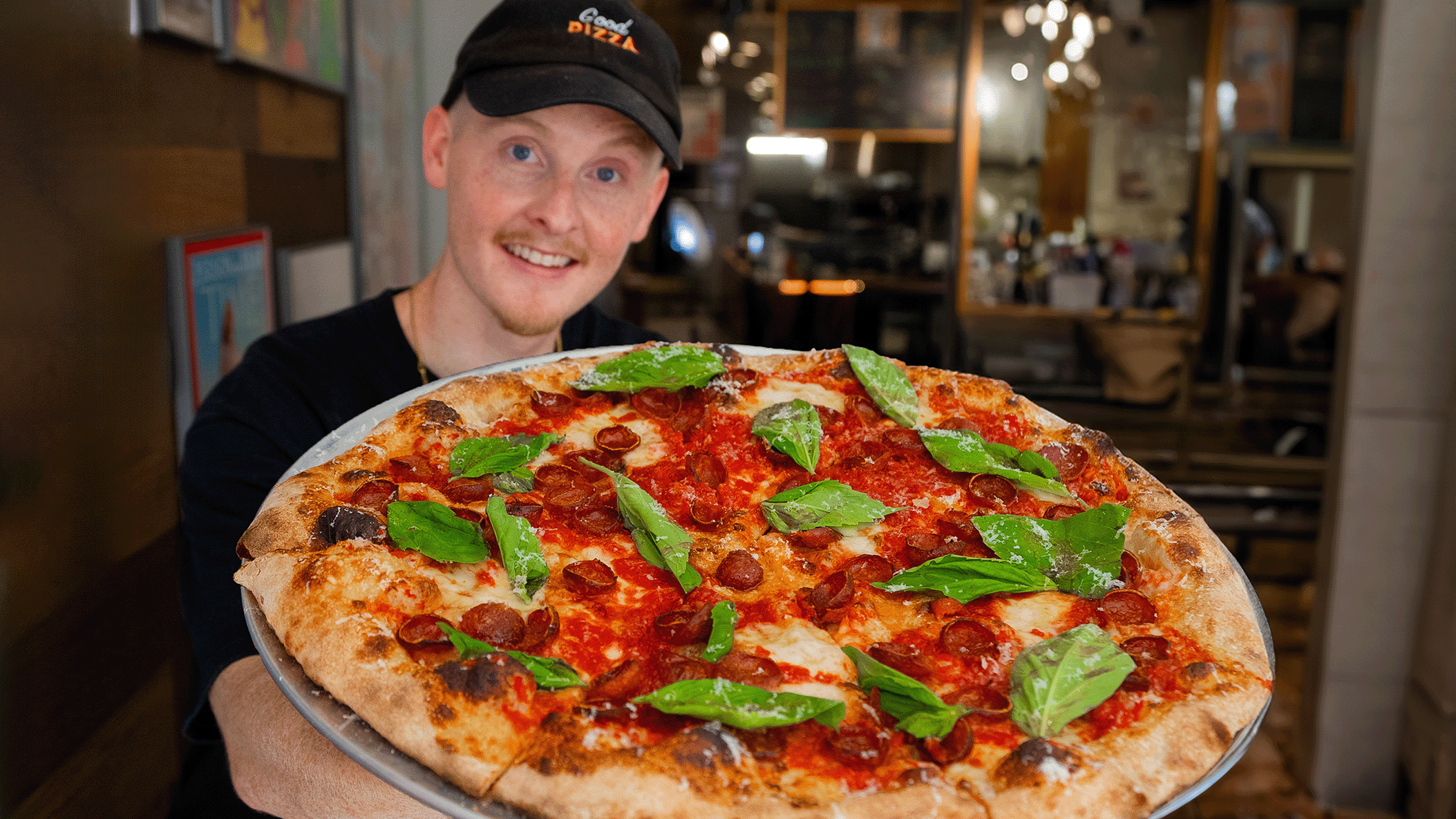 Charlie Anderson holding a fresh pizza
